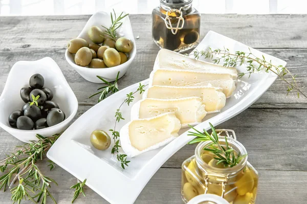 Olives are green and black with soft cheese with mold like brie, Camembert with olive oil and thyme.