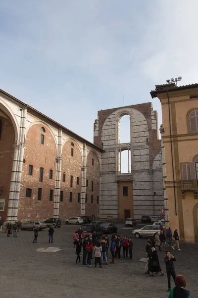 Neúplný fasáda plánované Duomo nuovo a lidí na náměstí před ním. Facciatone. Siena. Toskánsko Itálie. — Stock fotografie