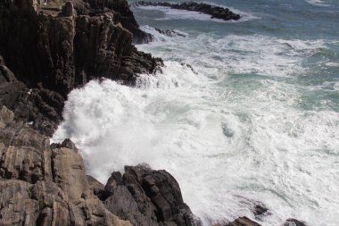 Dalga taşlardan oluşan bir gruba çarpıyor..