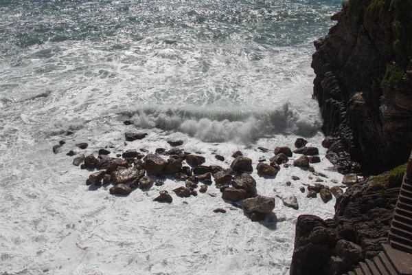 Морская волна катится к камням в солнечный день . — стоковое фото