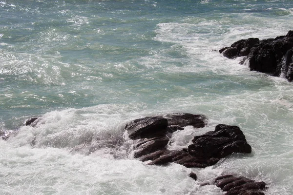 Las olas chocan contra un grupo de piedras. . — Foto de Stock