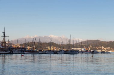 Günbatımında limanda tekneler, arka planda dağlar, La Spezia, Liguria, İtalya. 