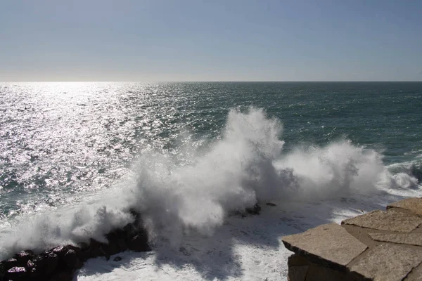 Seascape with horizon line over sea and wave is crashing stones.