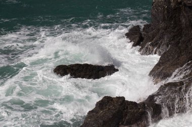 Dalga taşlardan oluşan bir gruba çarpıyor..