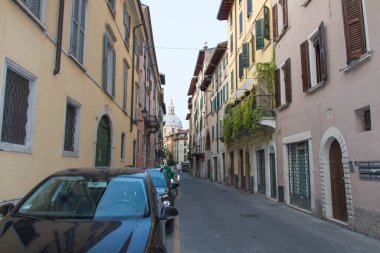Brescia, İtalya - 1 Ağustos 2018: Barış Kilisesi 'nin Aziz Meryem Kilisesi' nin arka plandaki dar sokak manzarası 1 Ağustos 2018, Lombardiya, İtalya.