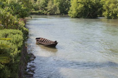 Güneşli bir günde nehirdeki bir teknenin manzarası.