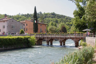 İtalya, Valeggio sul Mincio - 20 Mayıs 2018: Borghetto Valeggio sul Mincio 'nun nehir üzerindeki ahşap köprü manzarası, 20 Mayıs 2018' de Veneto, İtalya.