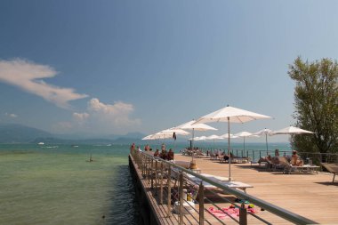 İtalya, Lombardiya - Ağustos 05 2018: Sirmione, İtalya 'da 05 Ağustos 2018' de Garda Gölü 'nde güneşli ahşap güverte manzarası.