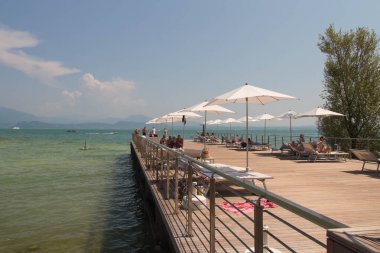 İtalya, Lombardiya - Ağustos 05 2018: Sirmione, İtalya 'da 05 Ağustos 2018' de Garda Gölü 'nde güneşli ahşap güverte manzarası.