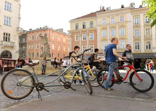 Mensen op de fiets op Rynok-plein in Lviv. — Stockfoto