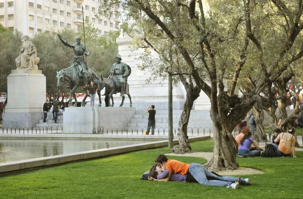 Casal deitado no gramado perto de monumentos Don Quixote, Madrid — Fotografia de Stock