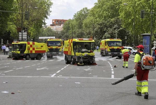 Sweeper teherautók és férfi tisztítószerek, az utcán, Madrid. — Stock Fotó