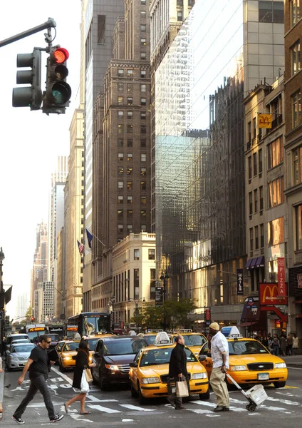 曼哈顿大街一景。纽约人在曼哈顿匆忙去应对他们的业务。人走在斑马线和黄色出租车在纽约. — 图库照片