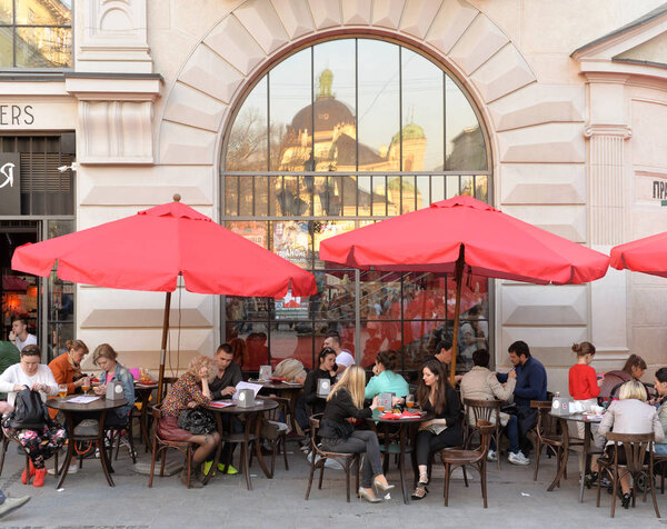 Lviv, Ukraine - April 2017: Tourists rest in cafe in sunny spring day in Lviv.