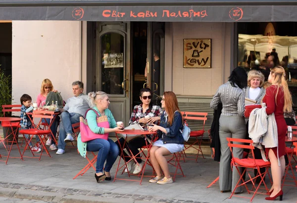 Turistas em café na Praça Rynok (Praça do Mercado) em Lviv, Ucrânia . — Fotografia de Stock