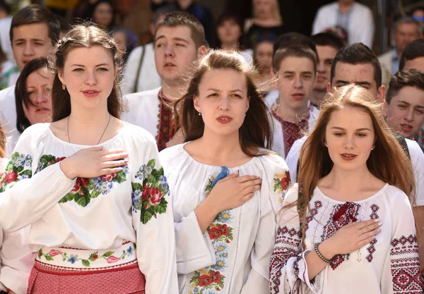Люди, носящие Вышыванку (традиционные украинские вышитые блузки), поют Государственный гимн во время празднования Дня Вышыванки во Львове, Украина . — стоковое фото