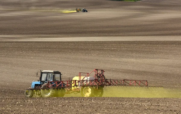 Traktor versprüht die Chemikalien auf dem Feld. Traktor streut Pestizide gegen Käfer auf landwirtschaftlichem Feld. — Stockfoto
