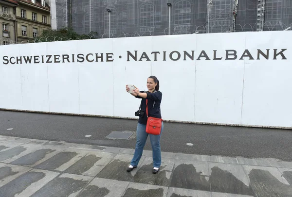 Une jeune femme fait du selfie près de la Banque nationale de Suisse à Berne . — Photo