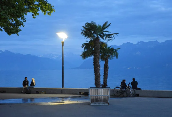 Lidé na nábřeží na Ženevském jezeře ve večerních hodinách, Lausanne, Švýcarsko. — Stock fotografie