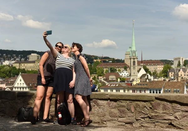 Junge Frauen machen Selfie mit Zürcher Stadtbild und Predigerkirche im Hintergrund. — Stockfoto