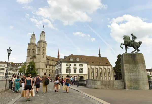 Orang-orang di jembatan Mnsterbrcke dekat gereja Great Minster (Grossmunster) dan monumen Hans Waldmann, Zurich, Swiss — Stok Foto