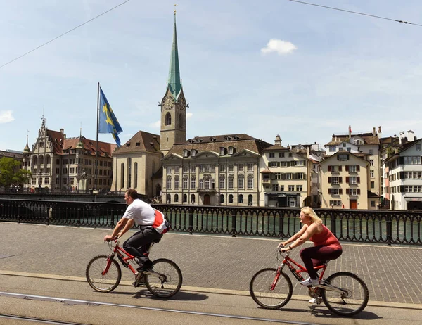 Kerékpárosok Zürich központjához és a Fraumunster templom. Mindennapi élet, Zürich. — Stock Fotó