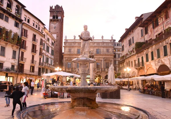 Estátua da fonte de Madonna Verona (Fonte de Nossa Senhora Verona) com Palazzo Maffei e torre Gardello ao fundo na Piazza delle Erbe em Verona, Itália . — Fotografia de Stock