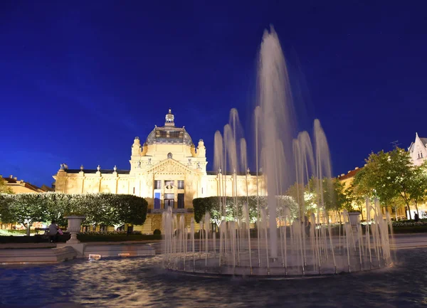 Fuente en el parque Ledeni y pabellón de arte en la noche en Zagreb, Croacia — Foto de Stock