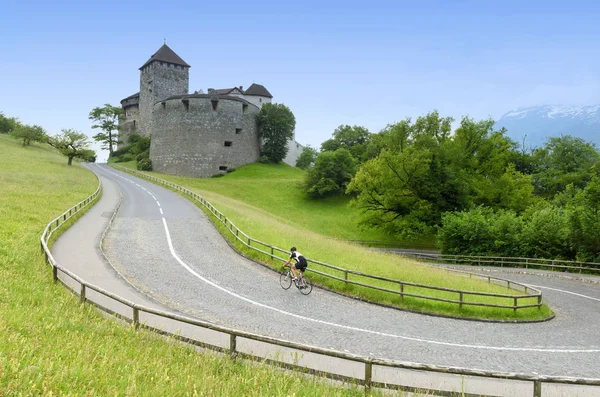 Um ciclista perto de Castelo em Vaduz, Liechtenstein . — Fotografia de Stock