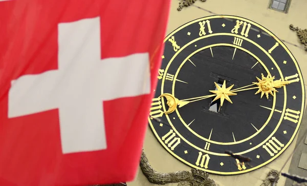 Schweizer Flagge vor dem berühmten Uhrenturm in bern, Schweiz. — Stockfoto