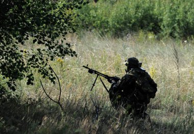 Silahlı bir asker. Askeri tatbikatlar, askeri operasyonlar.  