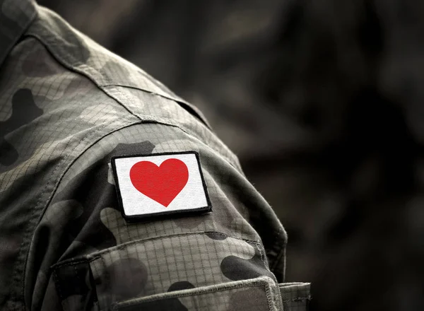 Askeri üniformada kırmızı kalp. Aşk ve savaş kavramı — Stok fotoğraf