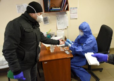Lviv, Ukrayna - 31 Mart 2020: Bir tıp çalışanı Lviv, Ukrayna 'daki bir otobüs şoförünün Coronavirus COVID-19 için hızlı bir test yaptı.