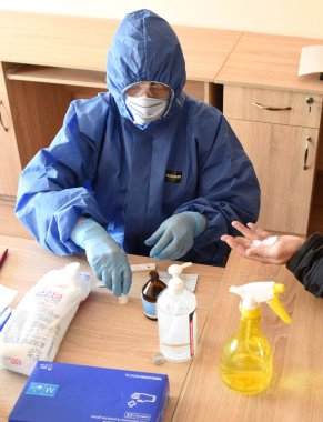 Lviv, Ukrayna - 31 Mart 2020: Bir tıp çalışanı Lviv, Ukrayna 'daki bir belediye çalışanının Coronavirus COVID-19 için hızlı bir test yaptı.
