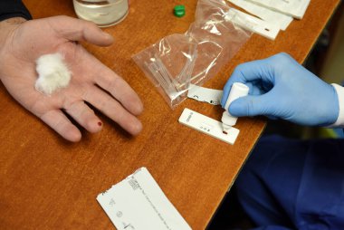 Lviv, Ukrayna - 31 Mart 2020: Bir tıp çalışanı Lviv, Ukrayna 'daki bir belediye çalışanının Coronavirus COVID-19 için hızlı bir test yaptı.