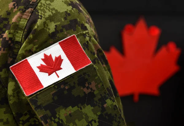Canada Day. Flag of Canada on the military uniform and red Maple leaf on the background. Canadian soldiers. Army of Canada. Canada leaf. Remembrance Day. Poppy day.