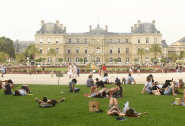 Paris, France - August 27, 2019: A people resting on the lawn in Luxembourg Gardens in Paris. clipart