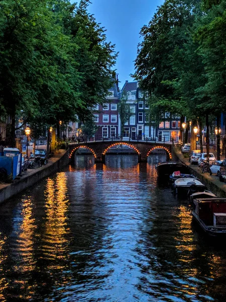 Sonnenuntergang auf den Amsterdam-Kanälen und holländischen Häusern, die sich im Wasser des Kanals spiegeln, amsterdam, Niederlande — Stockfoto
