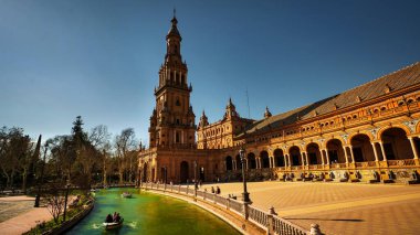 Seville, İspanya - 17 Şubat 2020 - Plaza de Espana / İspanya Meydanı Kanallı, tahta kürek çeken tekneler ve turistlerle İspanya 'nın Sevilla şehrinde.