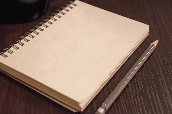 Caderno e lápis sobre mesa de madeira — Fotografia de Stock