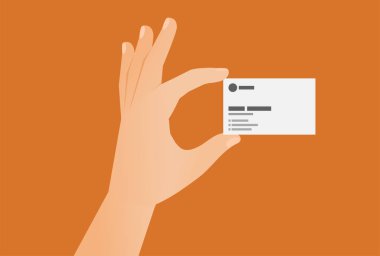 Hand holding a business card template with space for text isolated on orange background.
