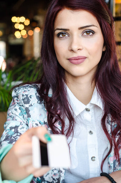 woman gives bank card into the camera. 