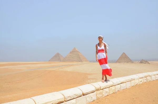 Жінка йде спереду пірамід — стокове фото