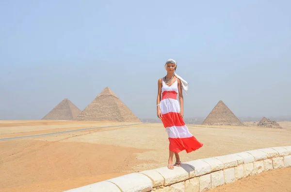 Mulher andando frente de pirâmides — Fotografia de Stock