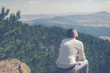 Bir kayanın üzerinde oturan adam 