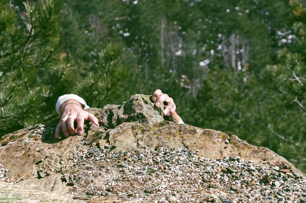 hands climbing on the edge of the wall