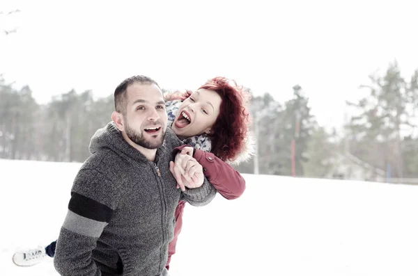 Chico y chica disfrutando en la nieve y riendo —  Fotos de Stock