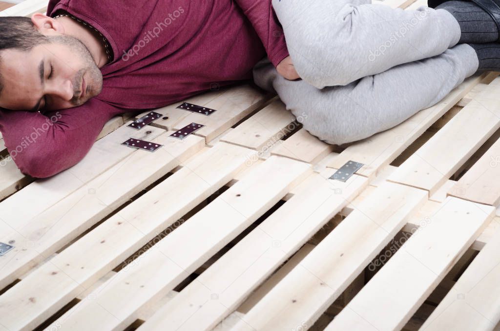 man lying on  wooden bed