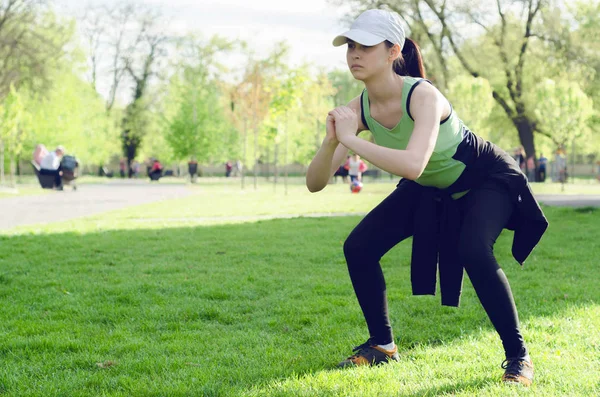 Молодая девушка в кепке делает упражнения — стоковое фото