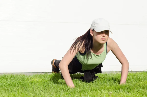 Jovem com um boné fazendo os exercícios — Fotografia de Stock